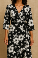Hibiscus Cluster Rayon Challis Fabric in black and white, styled as a tropical floral wrap dress for summer or vacation wear.