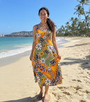 "Hawaiian woman wearing a tropical summer dress made of Tiare Sea Turtles Polynesian Tribal Design Rayon Fabric on a sunny beach."