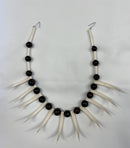 Ula Nifo lei necklace featuring sharp white shells and round brown beads.
